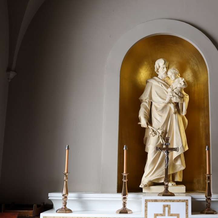 statua d'oro dell'uomo che tiene la croce puzzle scorrevole online