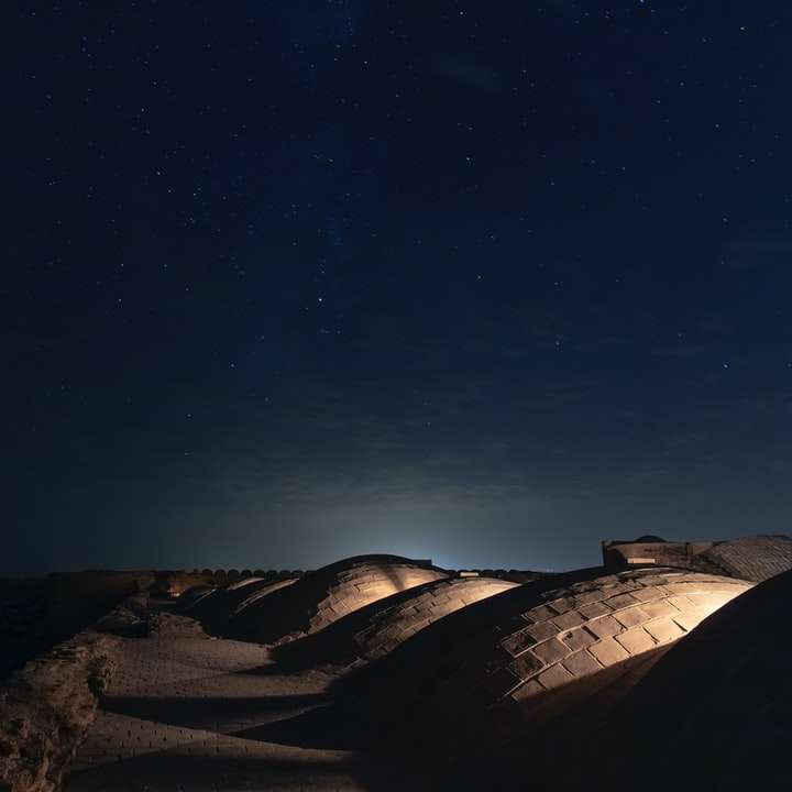 areia marrom sob o céu azul durante a noite puzzle online