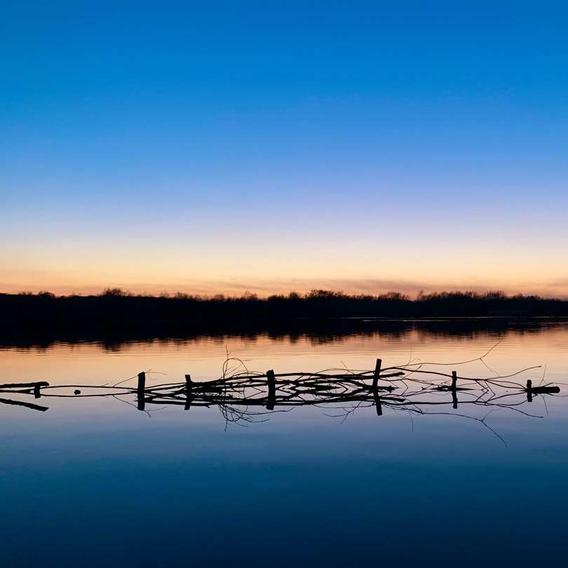 bruin houten hek op meer tijdens zonsondergang schuifpuzzel online