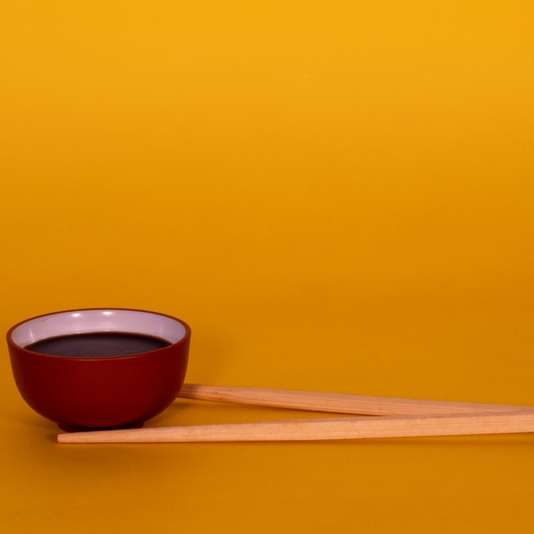 коричневые деревянные палочки для еды на красной и черной керамической миске онлайн-пазл