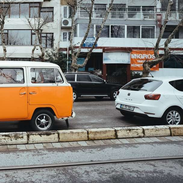 volkswagen t-2 laranja e azul estacionado na calçada puzzle online