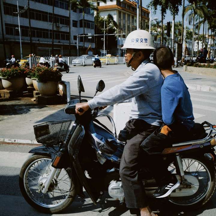 homem de paletó azul andando de motocicleta preta durante o dia puzzle deslizante online