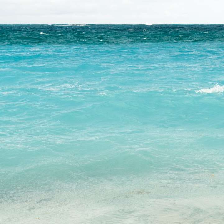 Blått havsvatten under dagtid glidande pussel online