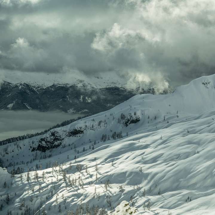 pokryte śniegiem góry pod zachmurzonym niebem w ciągu dnia puzzle online