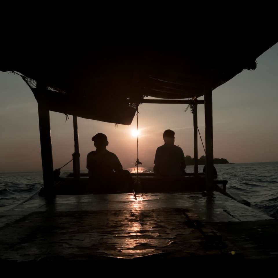 deux, silhouette, de, personne assise, près, océan, soir puzzle coulissant en ligne