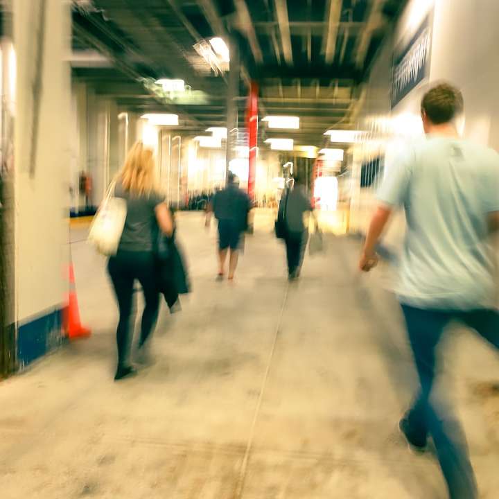 man in white t-shirt and blue denim jeans walking on hallway online puzzle