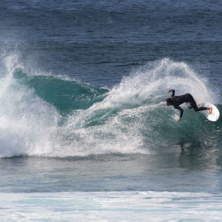 Hombre surfeando sobre las olas del mar durante el día puzzle deslizante online