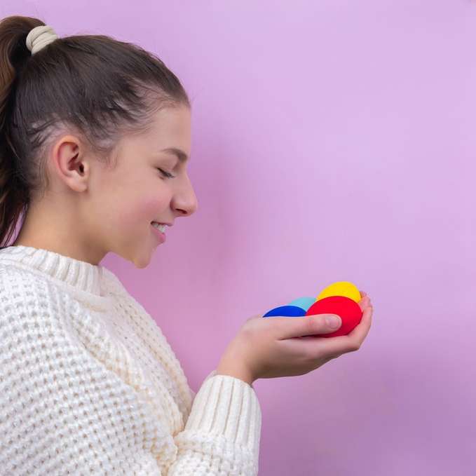 žena v bílém pleteném svetru drží modrý míč posuvné puzzle online