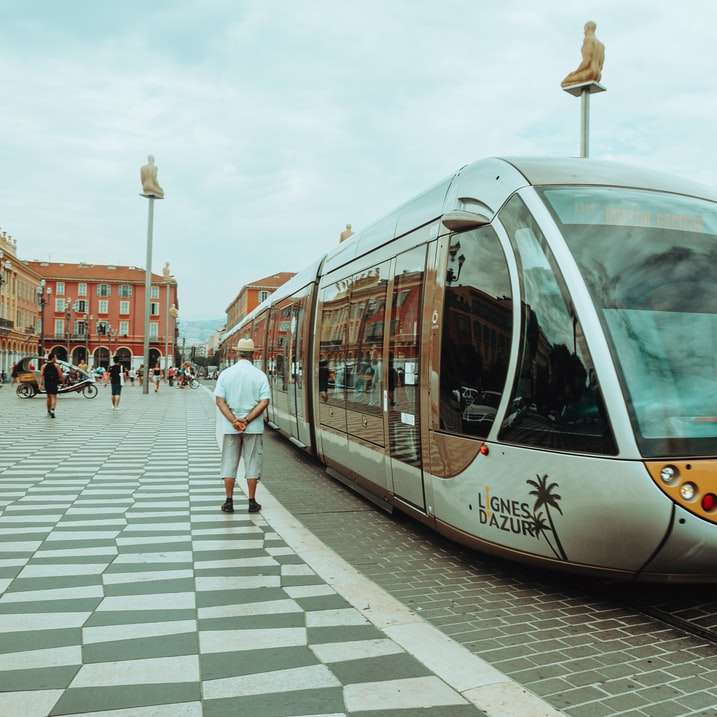 lidí, kteří jdou po chodníku poblíž bílé a žluté tramvaje posuvné puzzle online