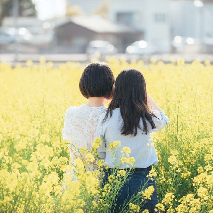 woman in white shirt standing on yellow flower field online puzzle