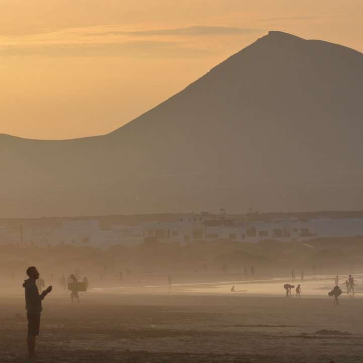 Man och kvinna som står på stranden under solnedgången glidande pussel online