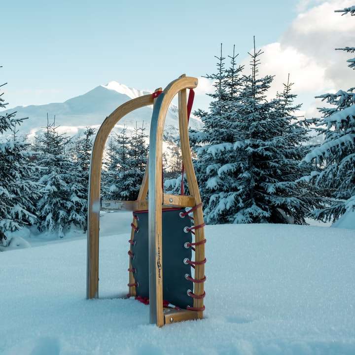 Traîneau à neige en bois brun sur un sol couvert de neige pendant la journée puzzle en ligne