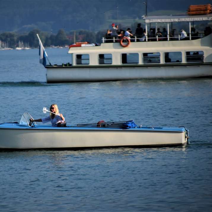 люди катаються на біло-блакитному човні вдень розсувний пазл онлайн