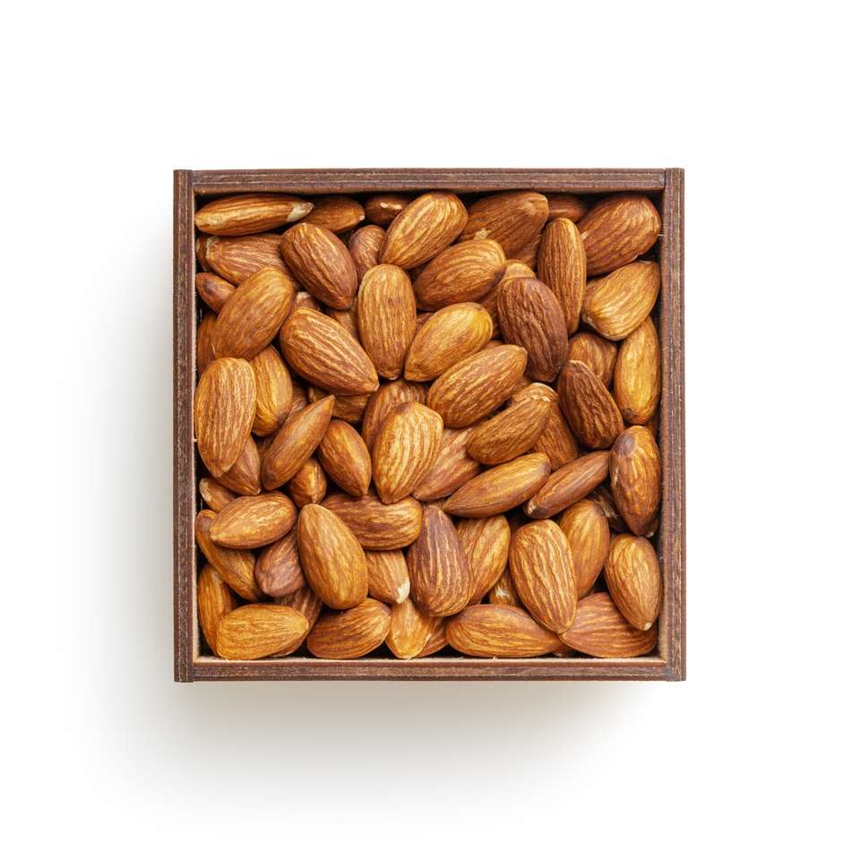 Hnědé mandlové ořechy na bílém povrchu online puzzle