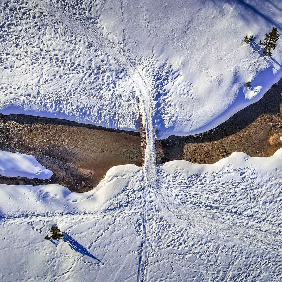 Vue aérienne du champ couvert de neige pendant la journée puzzle en ligne