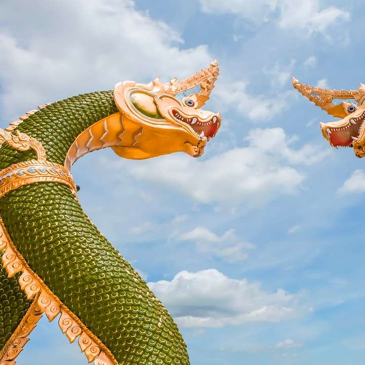 Estátua de dragão de ouro sob o céu azul durante o dia puzzle deslizante online
