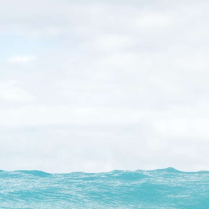 Син океан под бяло небе през деня онлайн пъзел