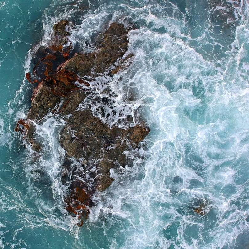 brązowa formacja skalna na ciele wody w ciągu dnia puzzle online