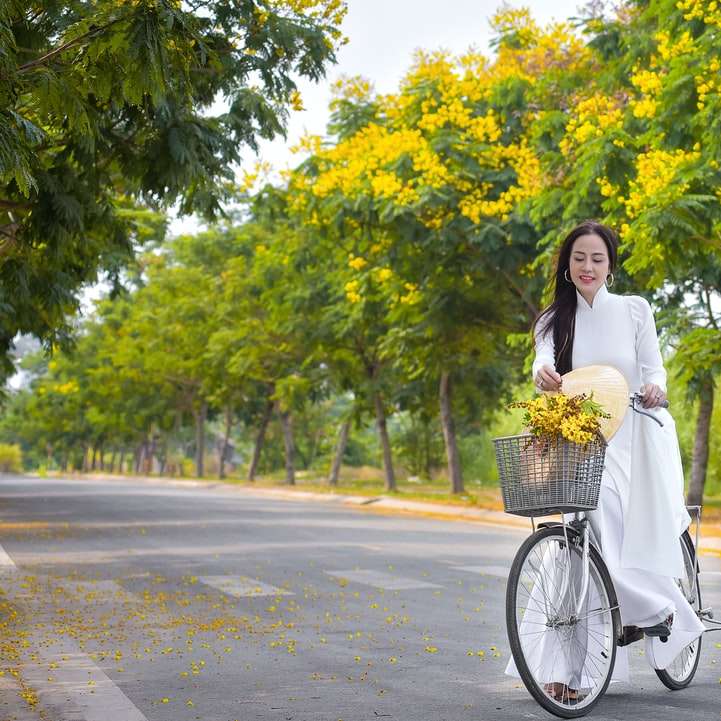 Kvinna i vit långärmad klänning som håller bukett blommor Pussel online