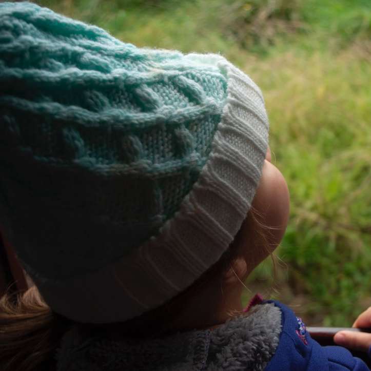 Criança, em, jaqueta azul, e, branca, knit, boné puzzle deslizante online