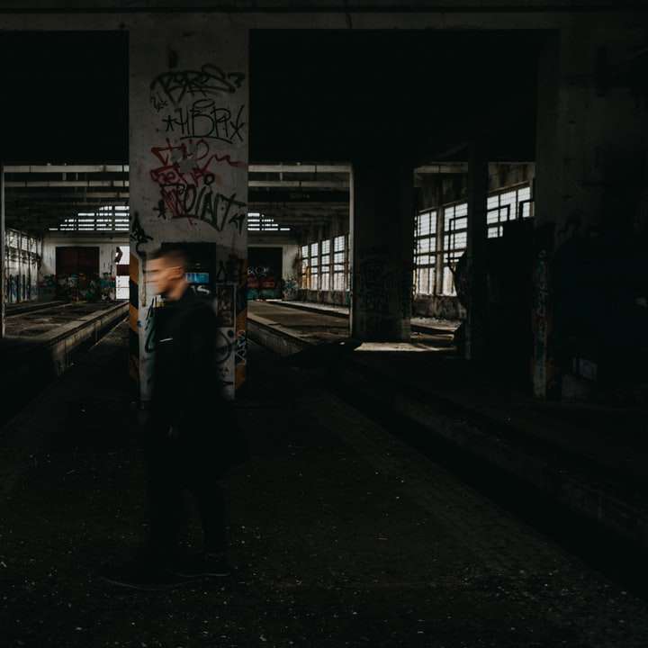 Ο άνθρωπος σε μαύρο σακάκι που στέκεται στο πεζοδρόμιο κατά τη διάρκεια της νύχτας online παζλ