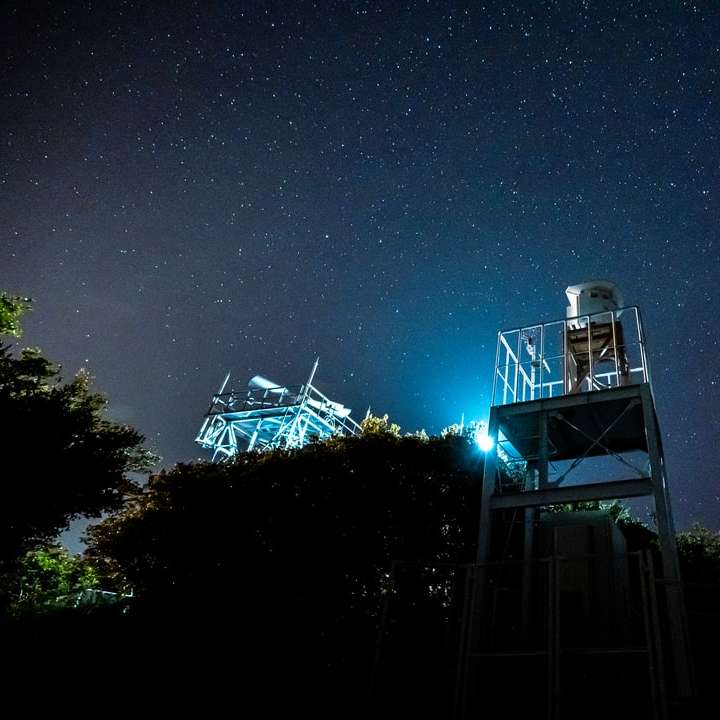 Witte en zwarte toren onder blauwe hemel tijdens nachttijd schuifpuzzel online
