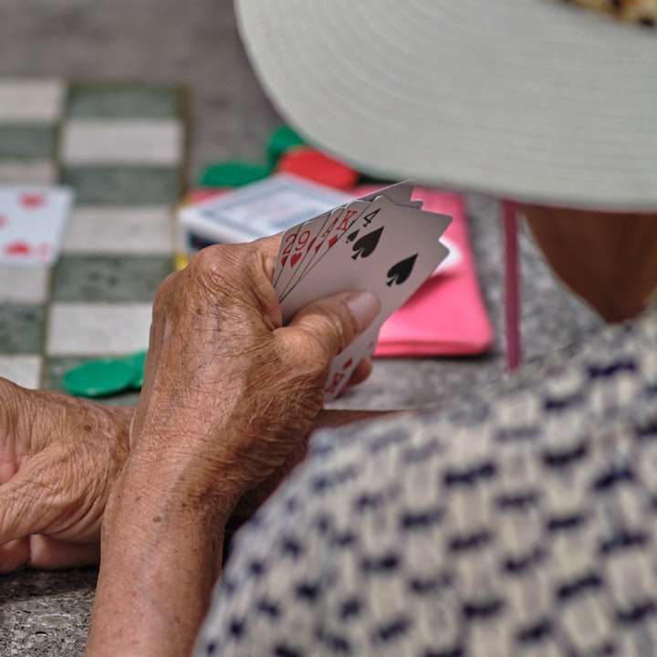 Osoba drží bílé a černé hrací karty posuvné puzzle online