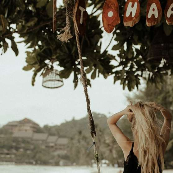 Nő fekete tartály tetején lógott barna fából készült swing online puzzle