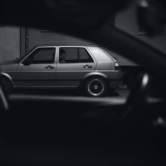 Graustufenfoto des Autos in einem dunklen Raum Schiebepuzzle online