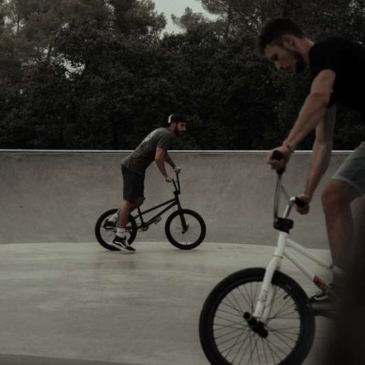 Человек в черной майке катается на белом велосипеде BMX онлайн-пазл