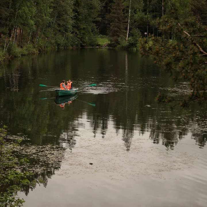 Zöld csónak a tónál a zöld fák közelében nappali csúszó puzzle online