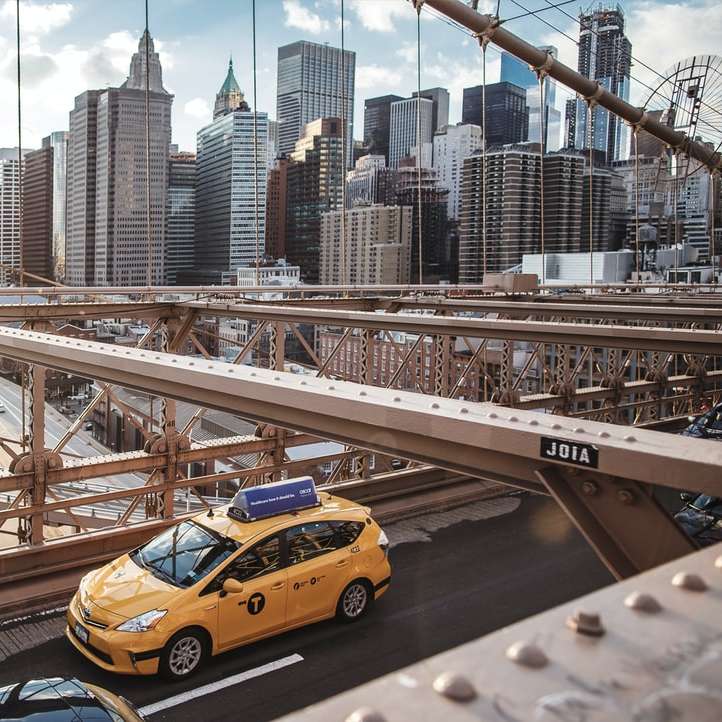 yellow taxi cab on bridge during daytime sliding puzzle online