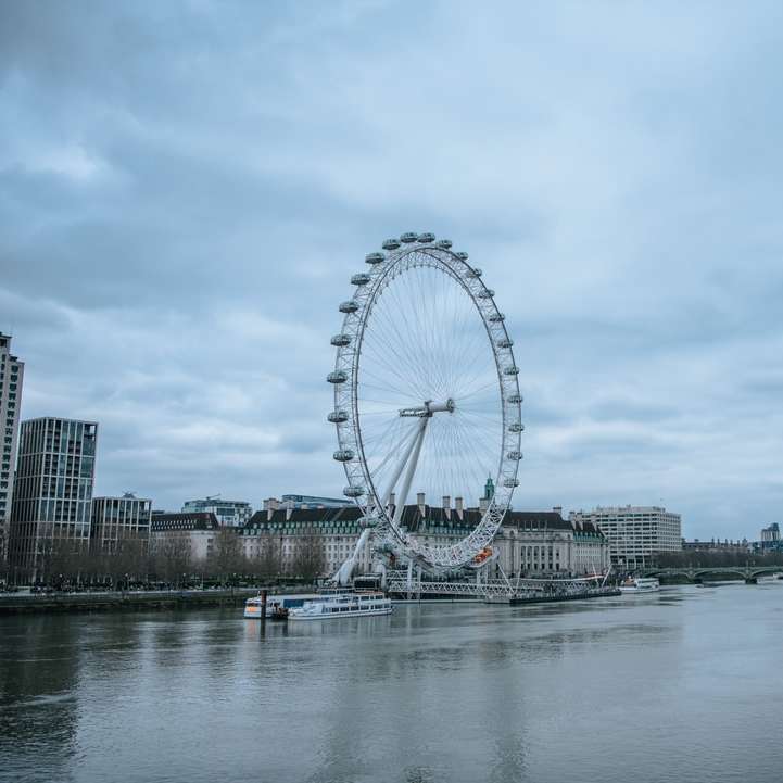 Ferris Wheel lângă corpul de apă sub cerul noros alunecare puzzle online