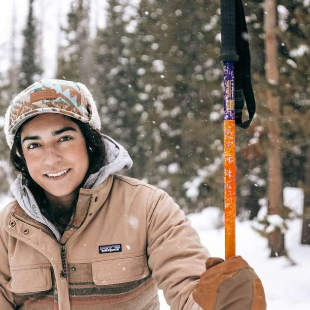 Vrouw in bruin jasje die zich op sneeuw behandelde grond bevinden online puzzel