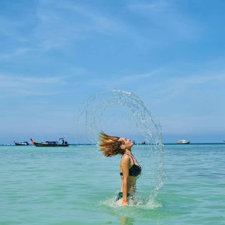 Kvinna i blå bikini på vatten under dagtid glidande pussel online