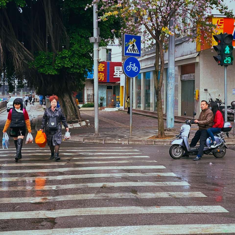 Lidé na koni motocyklu na chodci v jízdním pruhu během dne posuvné puzzle online