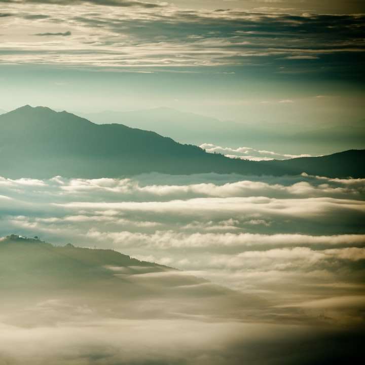 Λευκά σύννεφα πάνω από τα βουνά κατά τη διάρκεια της ημέρας online παζλ
