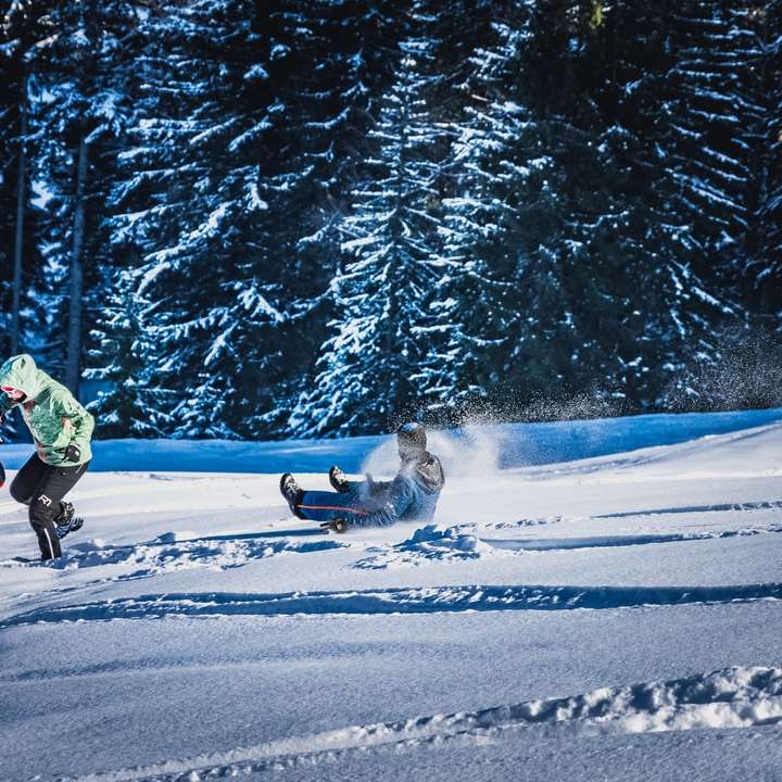 Човек в зелено яке езда на сноуборд през деня плъзгащ се пъзел онлайн