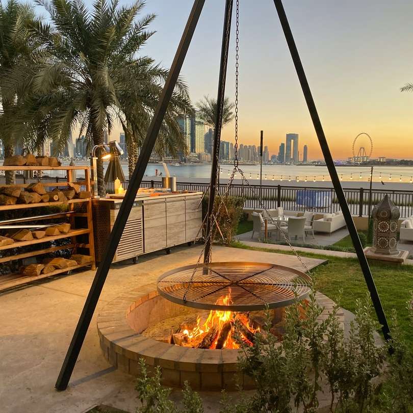 brown round fire pit with green palm trees during daytime online puzzle