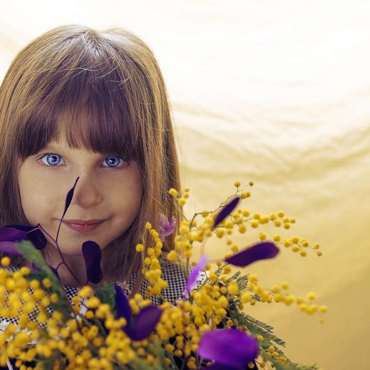 Девушка со светлыми волосами держит желтые цветы раздвижная головоломка онлайн