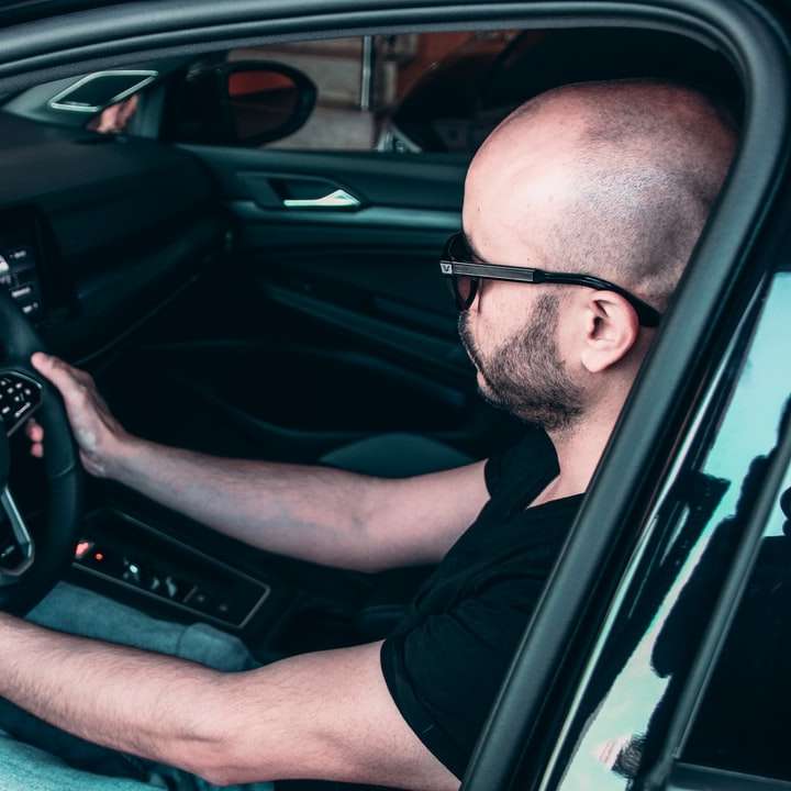 людина в чорній оправі окуляри за кермом автомобіля онлайн пазл