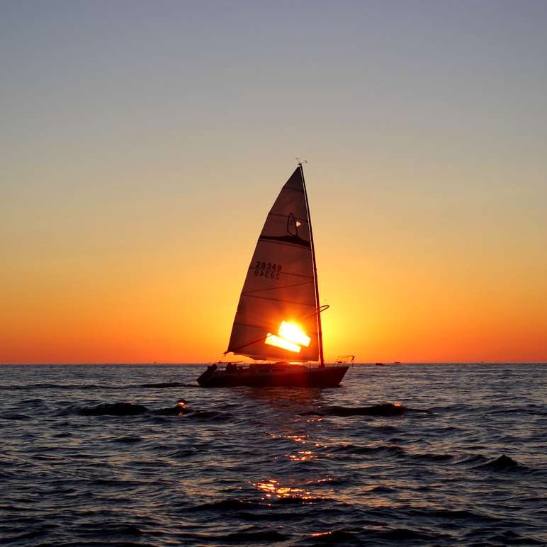 парусник в море во время заката онлайн-пазл