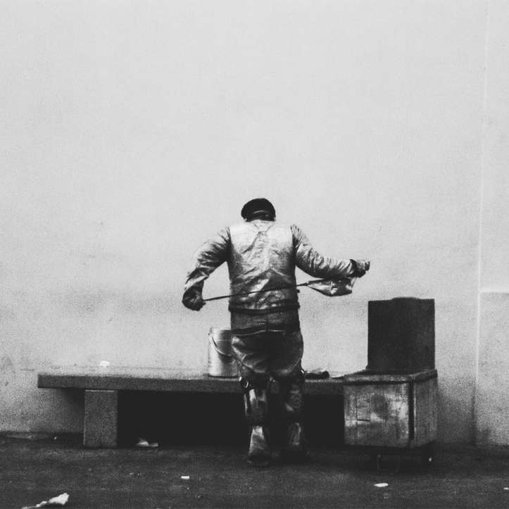 Man in jas en broek zittend op betonnen bank online puzzel