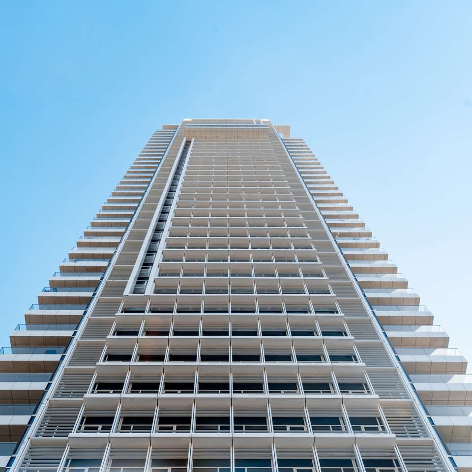 Edifício de concreto branco sob o céu azul durante o dia puzzle deslizante online