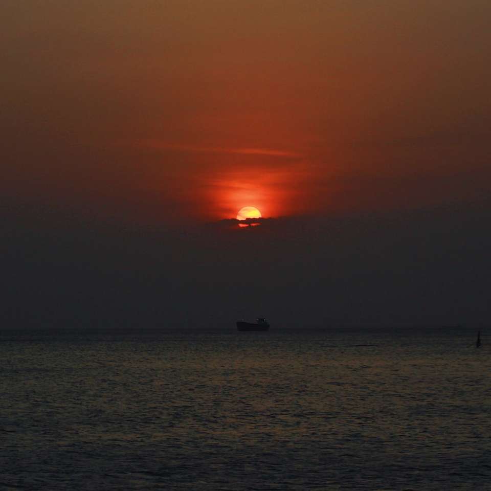 Silhuett av båt på havet under solnedgången Pussel online