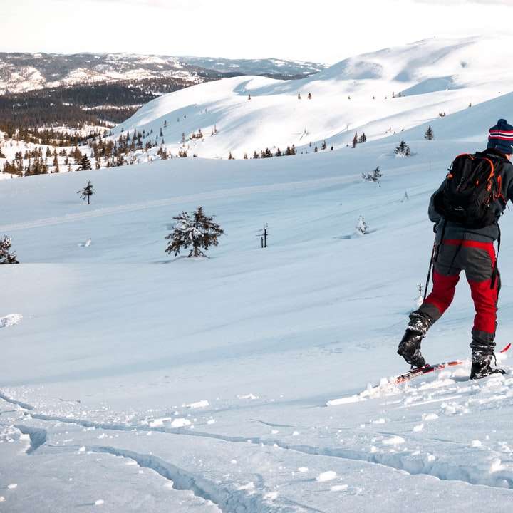 Човек в черно яке и черни панталони кацащи ски остриета плъзгащ се пъзел онлайн