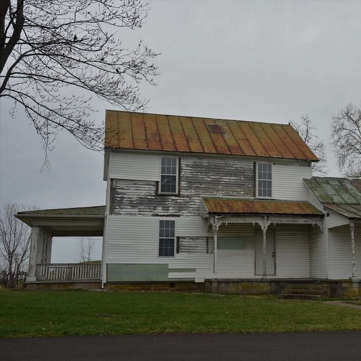 Biały i brązowy drewniany dom w pobliżu nagich drzew puzzle przesuwne online