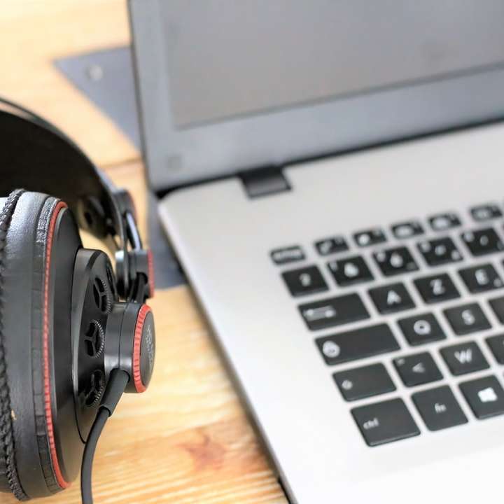 Svart och grå hörlurar på MacBook Pro glidande pussel online