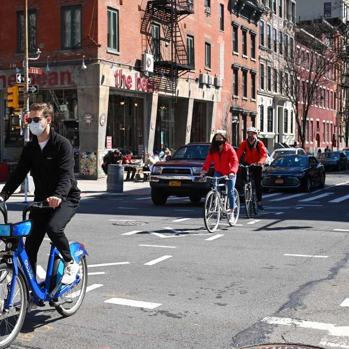 Ο άνθρωπος σε μαύρο σακάκι ιππασία μπλε ποδήλατο στο δρόμο συρόμενο παζλ online