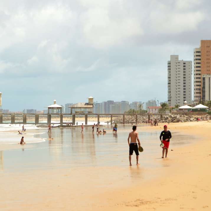 Хората вървят по плажа през деня плъзгащ се пъзел онлайн
